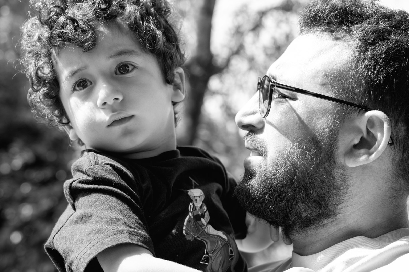 A father holding his child and looking closely at him